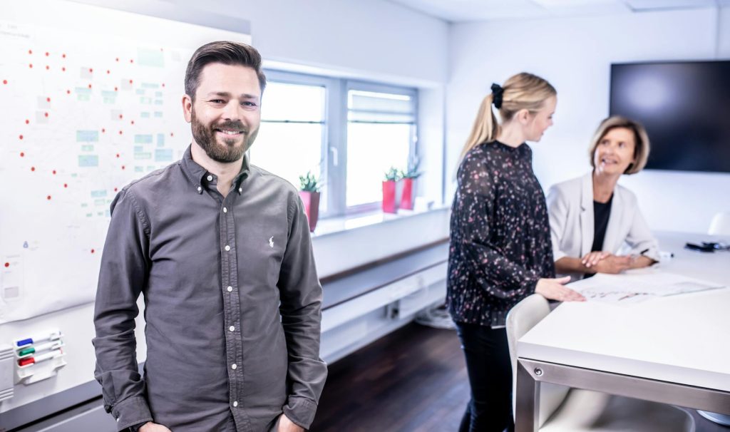 Smiling team meeting in office space with collaborative atmosphere and modern interior.